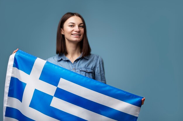 ギリシャの旗を保持している若い女性