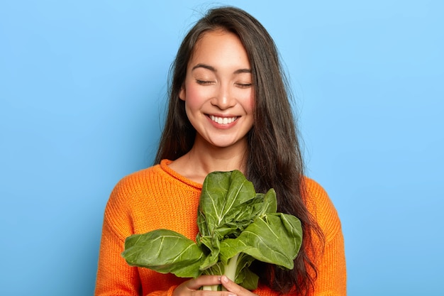 Young woman holding green leaves