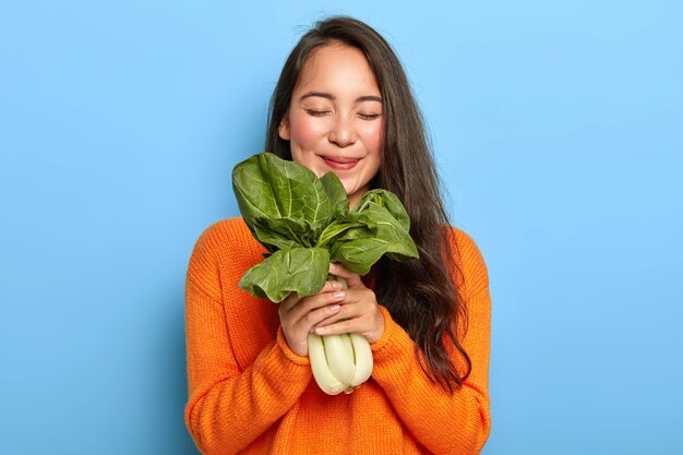 Young woman holding green leaves