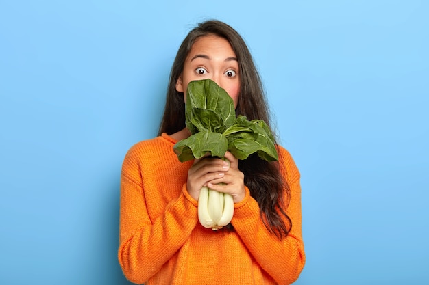 Young woman holding green leaves