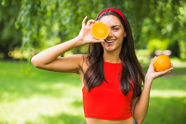 Молодая женщина с половиной оранжевый перед ее глазом