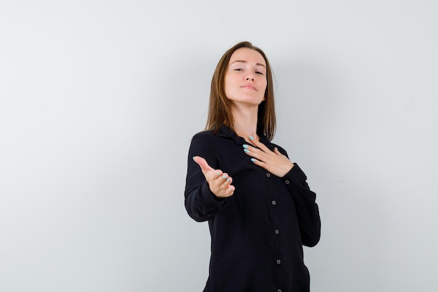 Young woman holding hand over chest