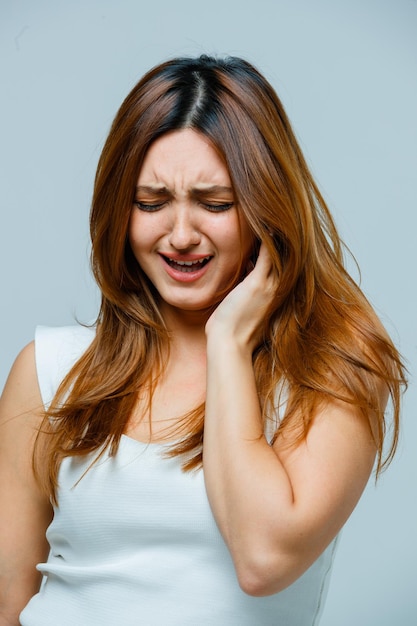 Young woman holding hand on ear and looking sad