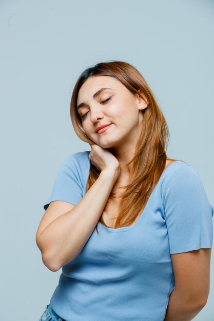 Young woman holding hand on neck and looking sleepy