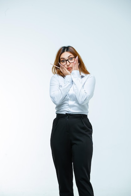 Free photo young woman holding hands on cheeks and looking surprised