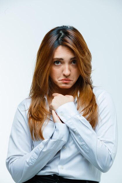 Young woman holding hands on chest and looking sad