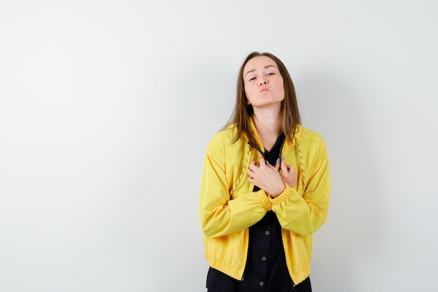 Young woman holding hands over chest and sending kisses