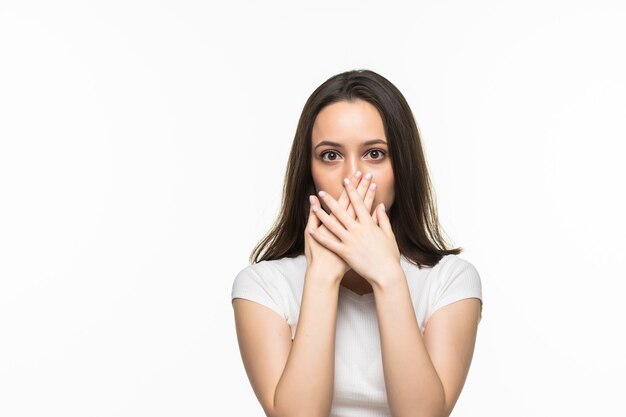 Young woman holding hands on her mouth on a white