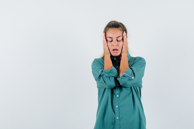 青いシャツを着て寺院に手をつないで疲れ果てているように見える若い女性