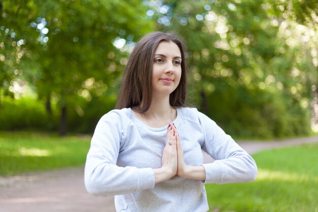 Young woman holding hands in Namaste