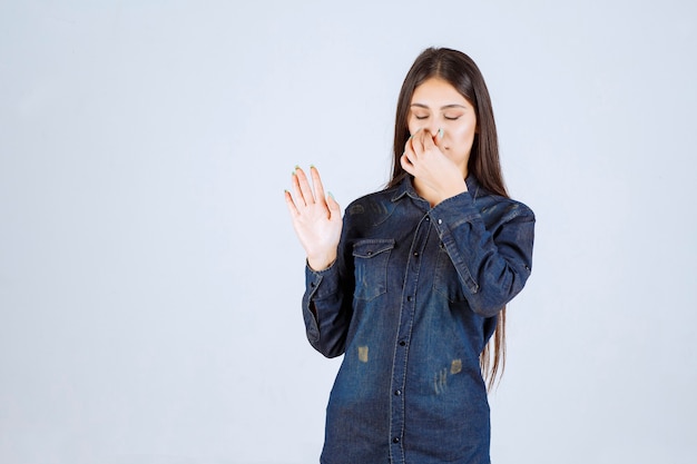 Young woman holding her bearth because of bad smell