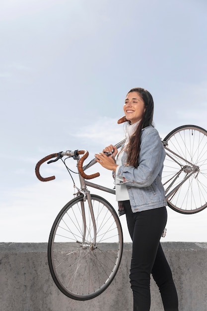 彼女の自転車を保持している若い女性