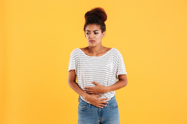 Free Photo young woman holding her stomach isolated