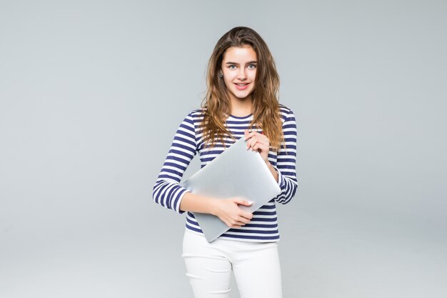 Молодая женщина держит ноутбук на белом фоне