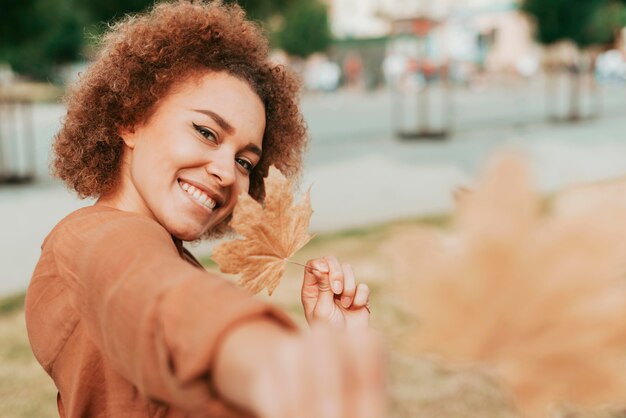 Young woman holding a leaf unfocused