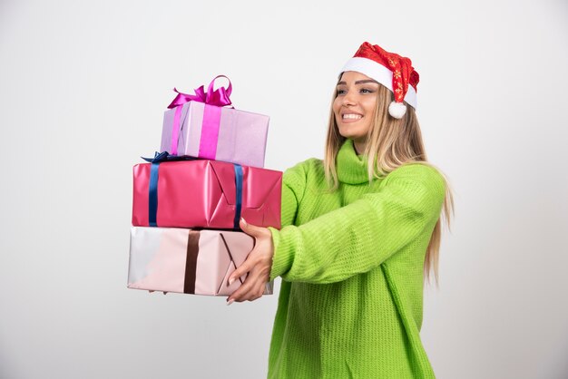 Young woman holding a lot of festive Christmas presents .