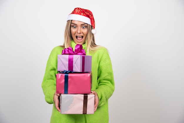 Young woman holding a lot of festive Christmas presents .