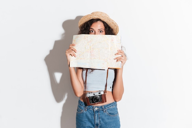 Young woman holding map and looking at camera isolated