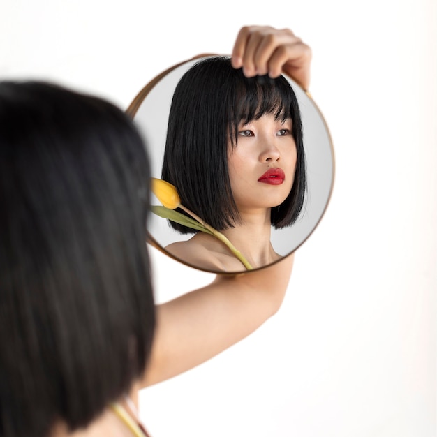 Free photo young woman holding mirror