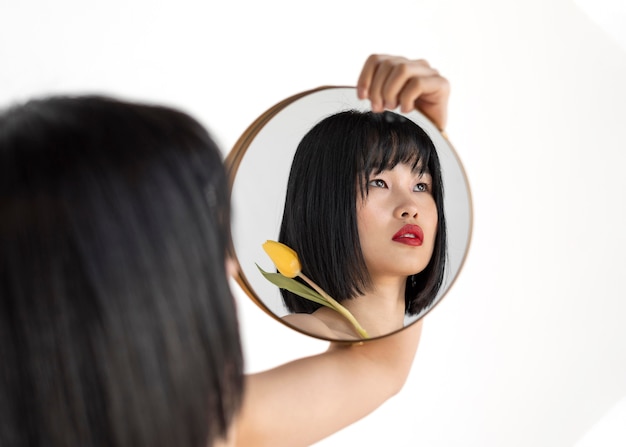 Free photo young woman holding mirror