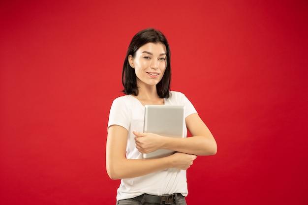 Молодая женщина, держащая ноутбук на красном