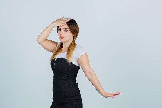 Young woman holding one hand on forehead and looking harried