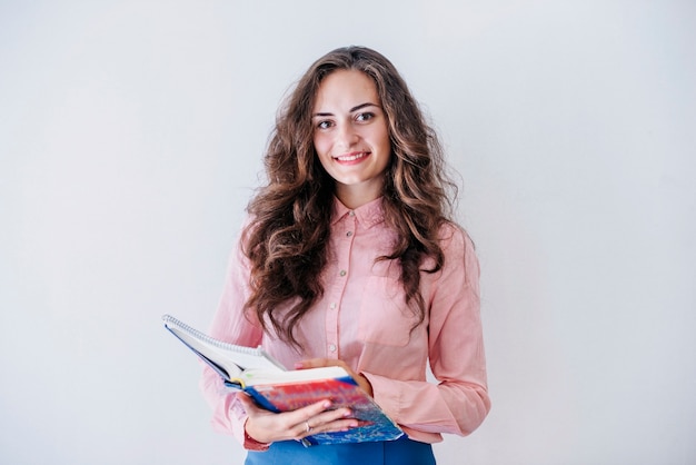 Young woman holding opened book in studio