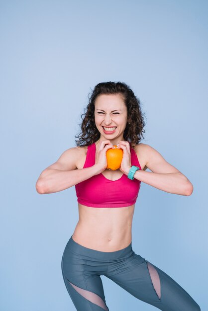 Young woman holding an orange