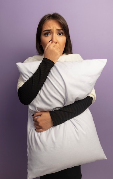 Free photo young woman holding pillow stressed and nervous biting nails