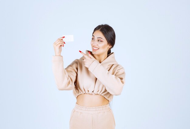 Young woman holding and presenting her business card