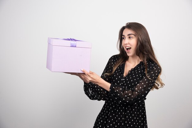 Young woman holding a purple gift box 