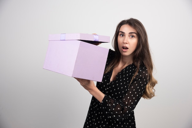 Foto gratuita giovane donna che tiene una confezione regalo viola