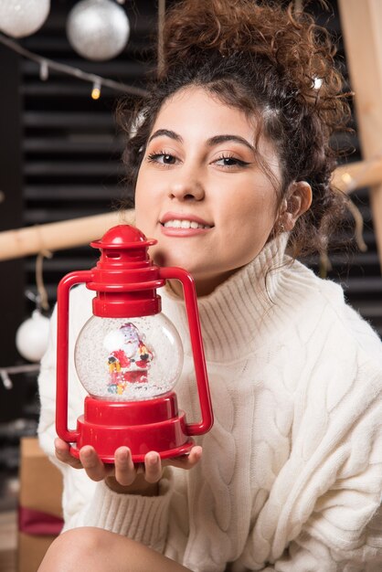 Young woman holding a red Christmas lamp 