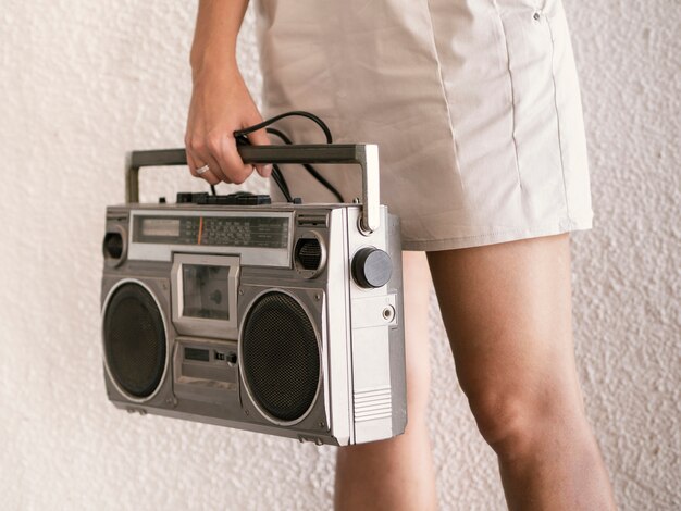 Young woman holding retro music player