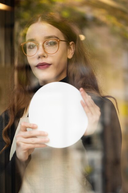 Young woman holding shop sign