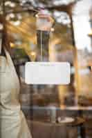 Free photo young woman holding shop sign