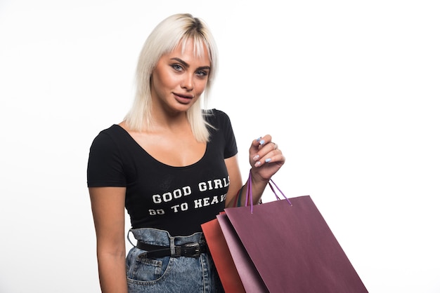 Young woman holding shopping bags on white background. High quality photo