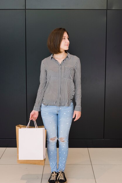 Free photo young woman holding shopping bags