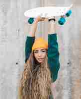 Free photo young woman holding skateboard