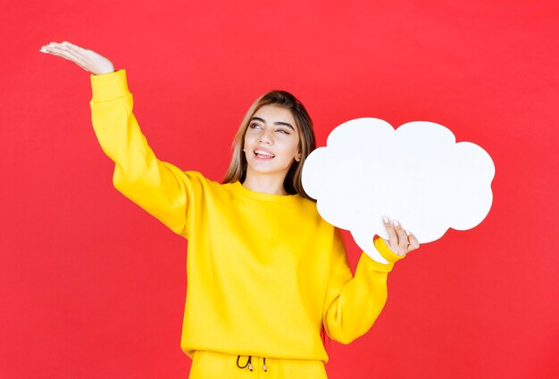 Young woman holding a speech bubble on red