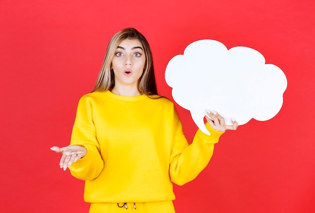 Young woman holding a speech bubble on red