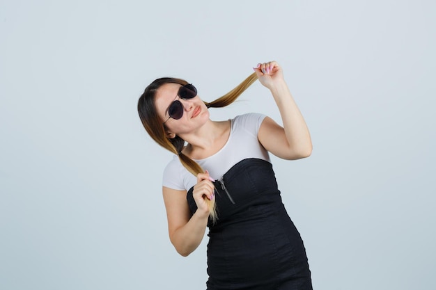 Young woman holding strand of hair