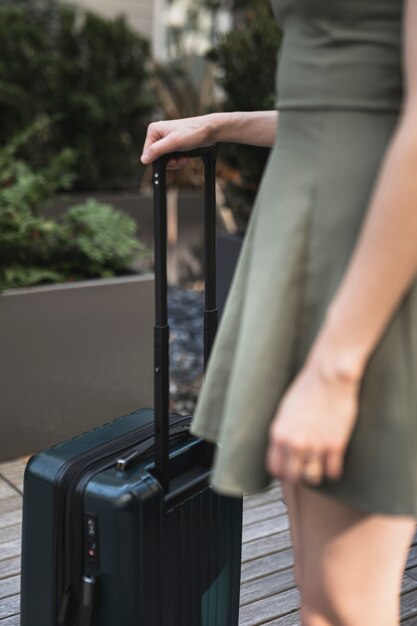 スーツケースを保持している若い女性