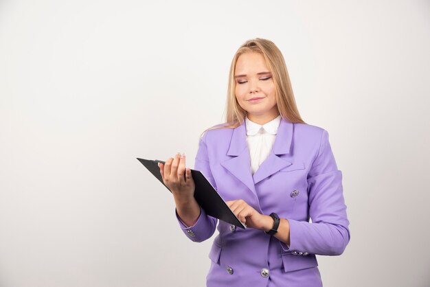 Young woman holding tablet on white.