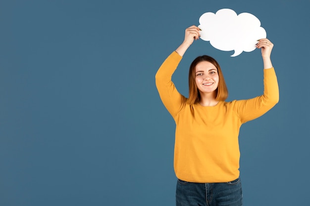 Free photo young woman holding a thought bubble with copy space