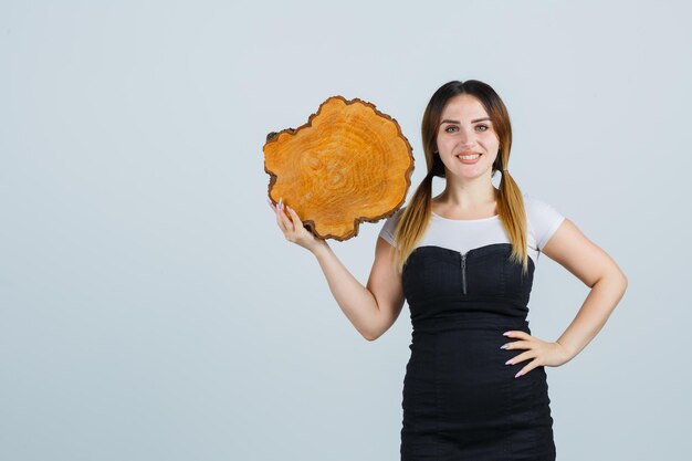 Young woman holding tree trunk slice