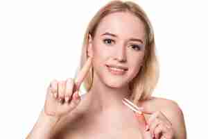 Free photo young woman holding tweezers for contact lenses and lens in front of her face on white background. eyesight and ophthalmology concept.