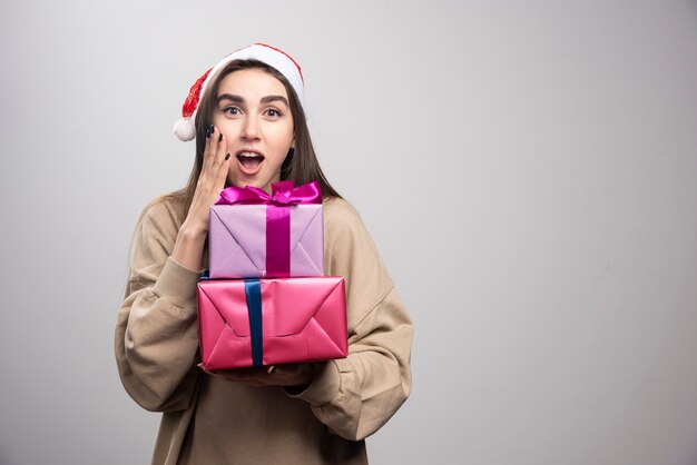 Young woman holding two Christmas presents .