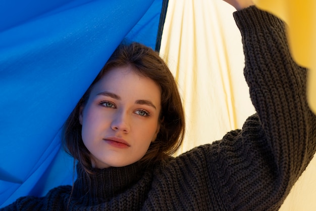 Free photo young woman holding ukrainian flag