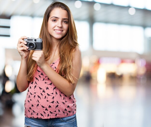 молодая женщина, держащая старинный фотоаппарат